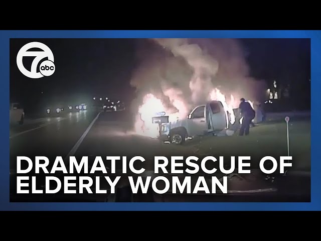 Dramatic video shows police officer saves elderly woman from burning vehicle