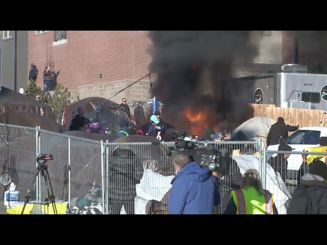 Fire, more buses during Denver migrant camp sweep