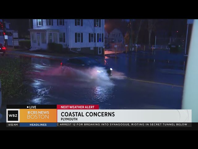 Drivers push through flooded street in Plymouth