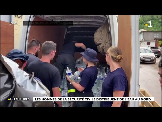 Les hommes de la sécurité civile distribuent de l'eau au Nord