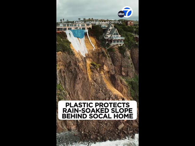 Plastic protects rain-soaked slope behind SoCal home