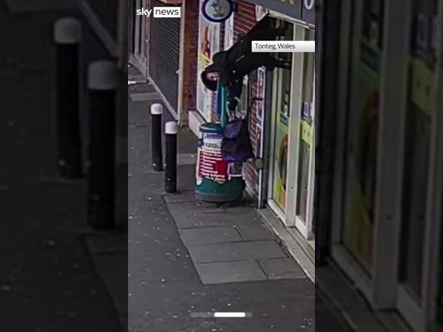 Woman lifted by shop shutters