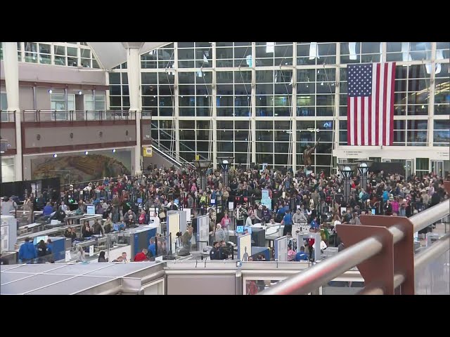 Travelers at Denver International Airport make arrangements ahead of a predicted snowstorm