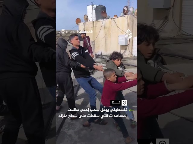 فلسطيني يوثق سحب إحدى مظلات المساعدات سقطت على سطح منزله