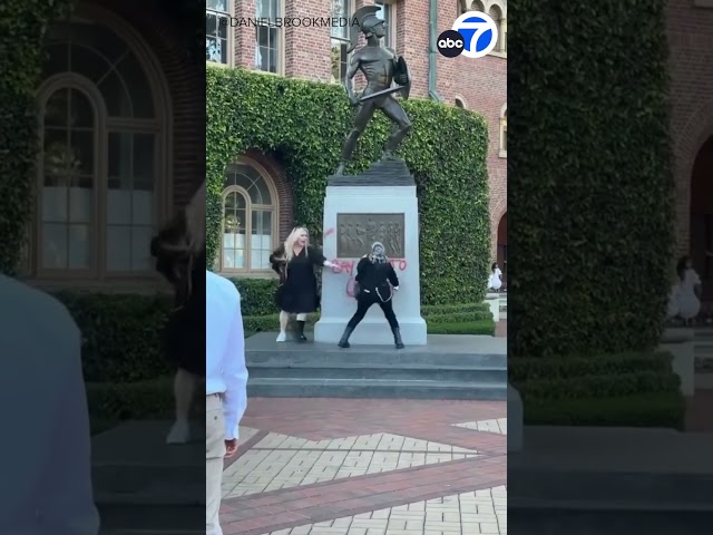 ⁣Protester spray-paints “Say no to genocide” on Tommy Trojan statue at USC