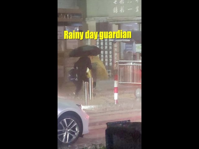 Principal guards students with umbrella on stormy morning
