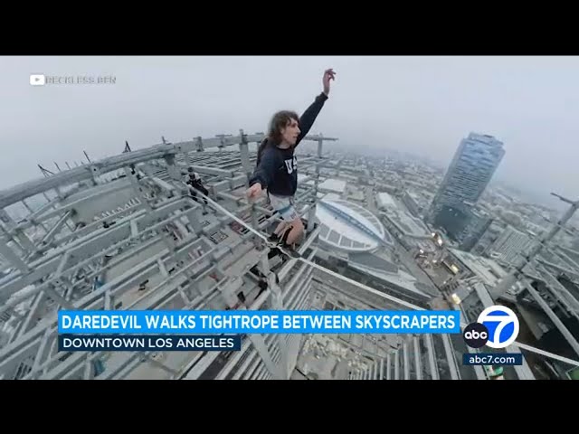 ⁣Daredevil walks tightrope between graffitied skyscrapers in downtown LA