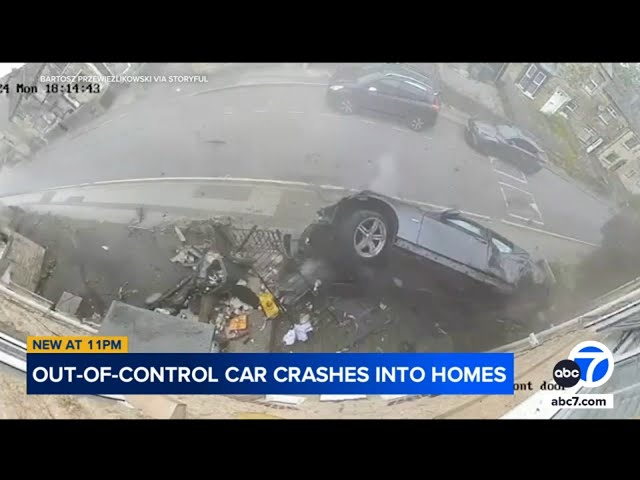 ⁣Shocking moment speeding BMW skids across road, crashes into homes