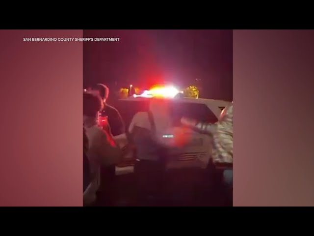 ⁣Teen arrested after group mobs sheriff's cruiser at IE street takeover