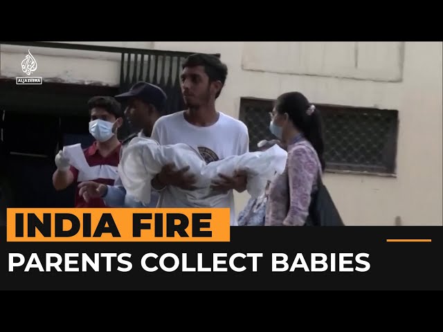 ⁣Parents collect their babies who died in New Delhi fire