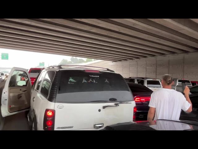⁣Cars in Dallas block traffic while trying to avoid hail