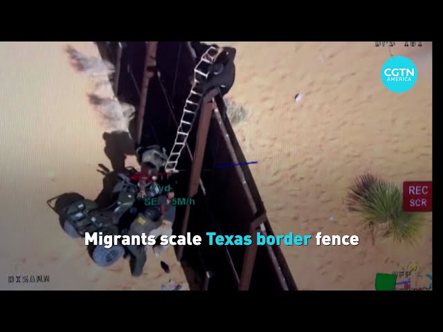 ⁣Migrants scale U.S. border fence