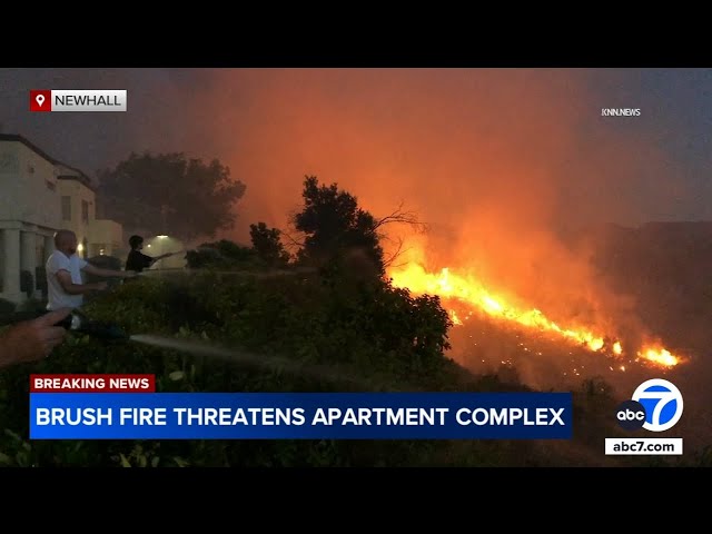 ⁣Newhall residents use garden hoses to keep fire away from homes