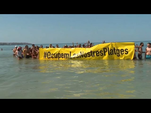 ⁣Decenas de activistas se dan un baño contra el turismo de masas en una playa de Mallorca