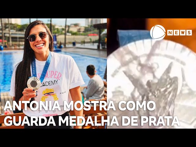 Lateral Antonia guarda medalha de prata com plástico filme