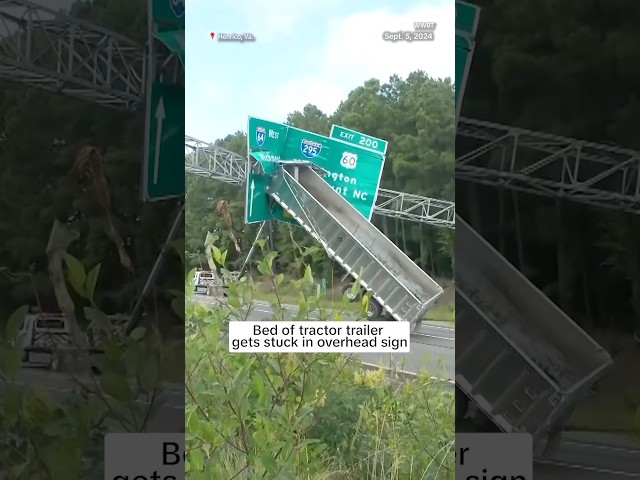 ⁣Bed of tractor trailer gets stuck in overhead sign