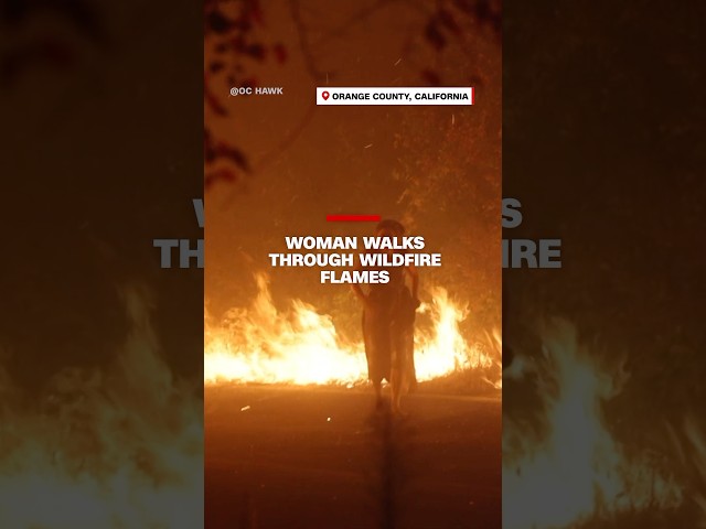 ⁣Woman walks through wildfire flames