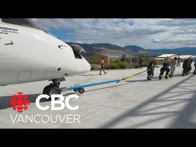 Teams of people pull airplane in charity event