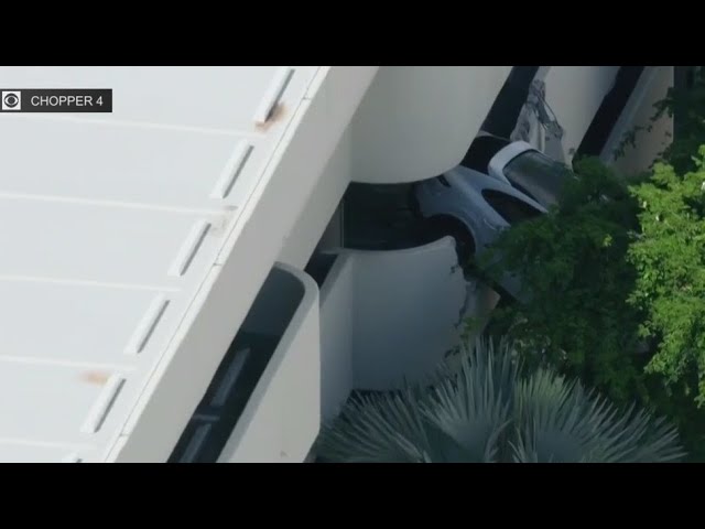 ⁣Driver rescued after car crashed through 3rd floor parking garage wall in Coral Gables