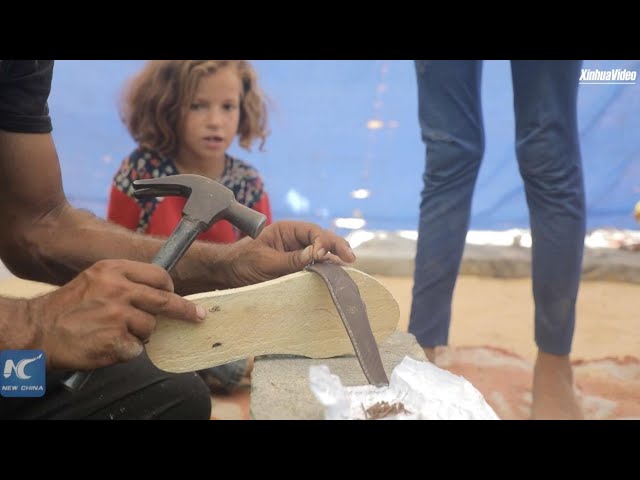 ⁣Palestinian carpenter makes wooden slippers for displaced Gazan children