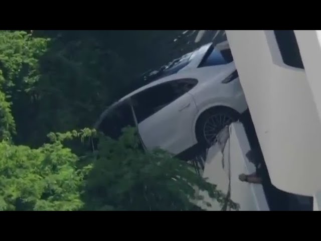 Video shows rescue of woman after car dangles from parking garage