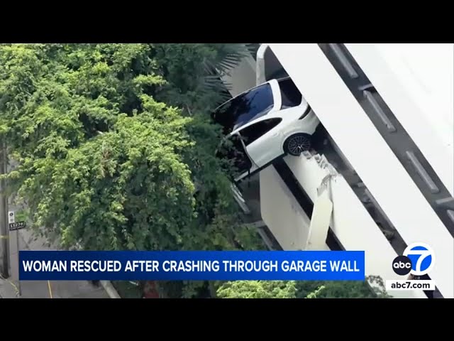 Woman slams her Porsche through parking garage wall