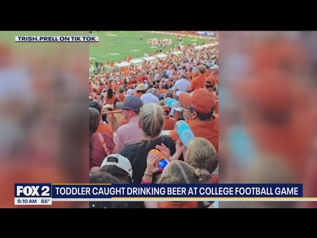 ⁣Toddler caught drinking beer at college football game