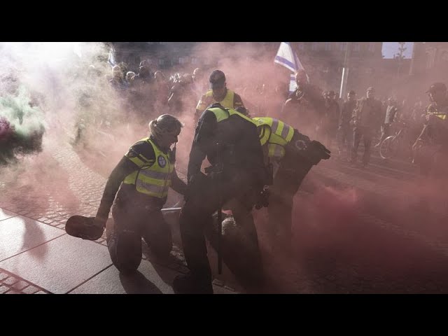 ⁣Police and Palestinian supporters clash in Amsterdam during 7 October commemorations