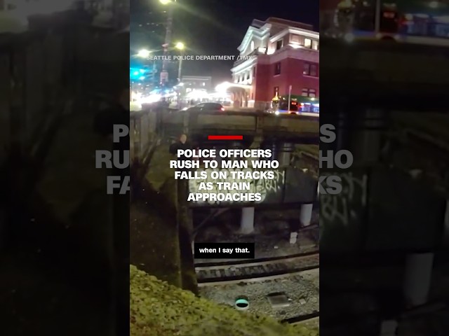 ⁣Police officers rush to man who falls on tracks as train approaches