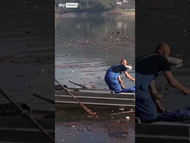 ⁣Volunteers clean up lake after deadly floods