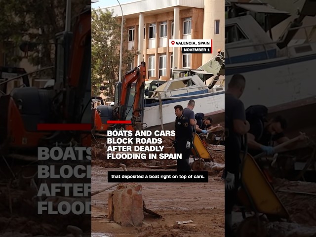 ⁣Boats and cars block roads after deadly flooding in Spain