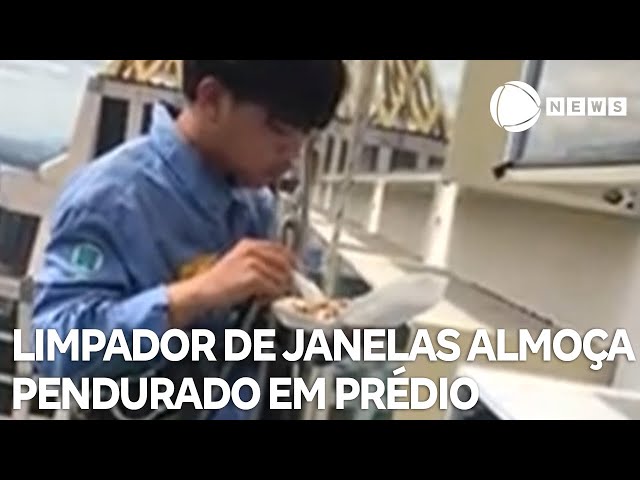 ⁣Limpador de janelas tailandês almoça pendurado em prédio