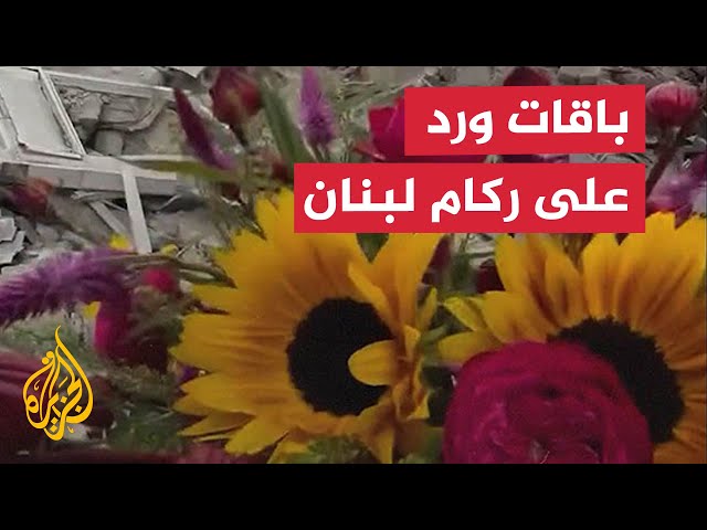 ⁣لبناني يضع باقات ورود على ركام المباني المدمرة بالضاحية الجنوبية