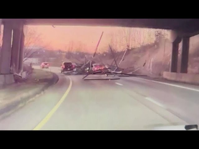 ⁣Video shows lumber truck on overpass losing load, sending building material onto car below