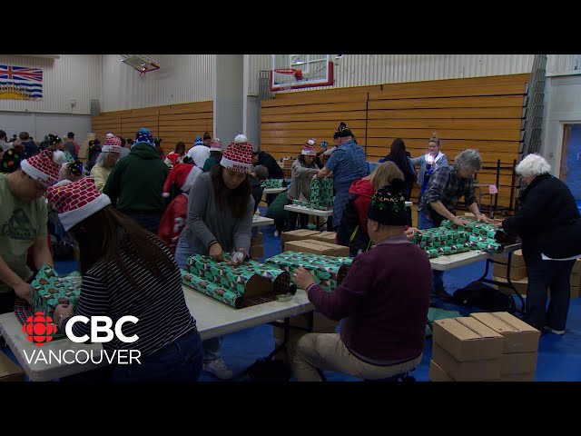 ⁣Volunteers wrap Christmas gifts and food hampers for kids and families