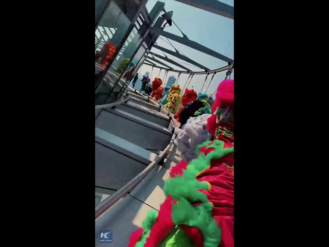 ⁣Lion dancers brave heights on the edge of Macao Tower