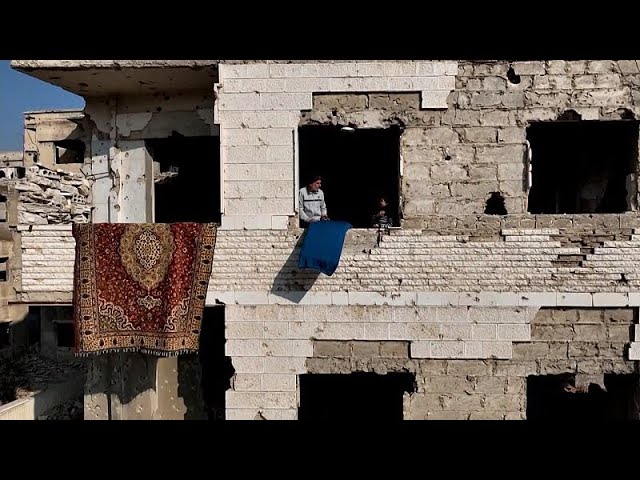 ⁣Ce couple de Syriens retrouve leur maison en ruines dans la ville fantôme de Harasta, dans la …