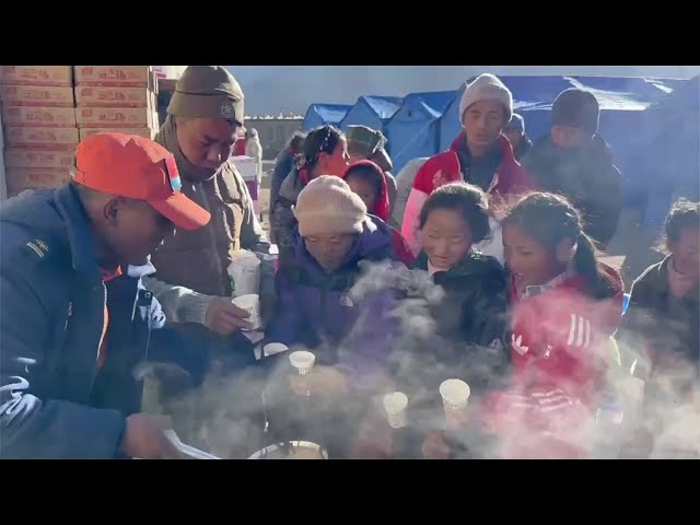 ⁣Fire brigade workers make warm food for people affected by quake