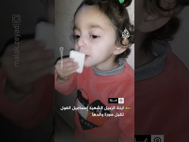 ⁣ابنة الزميل الشهيد إسماعيل الغول تقبل صورة والدها