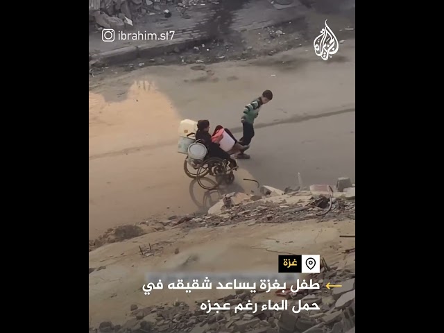 ⁣طفل بغزة بساعد شقيقه في حمل الماء رغم عجزه